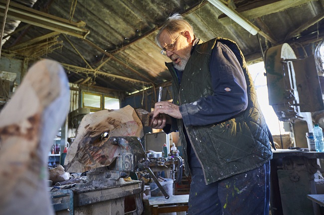 Albert King in his workshop wood carving